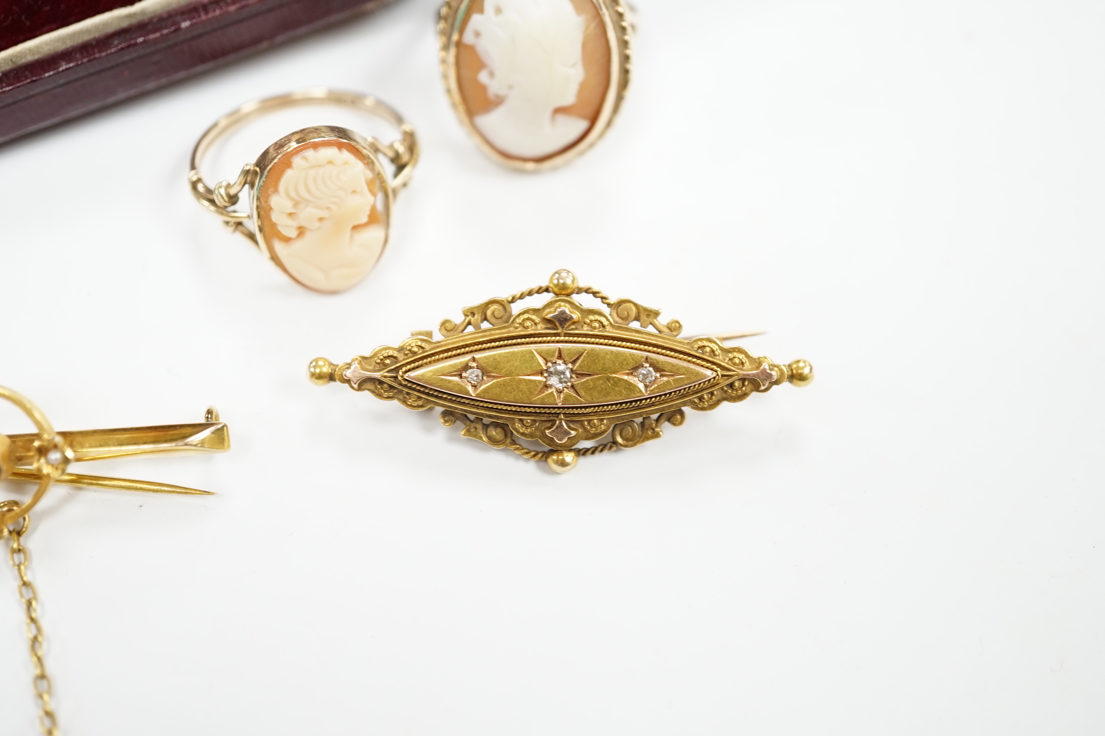 A late Victorian 15ct gold and three stone diamond chip set brooch, 43mm, an early 20th century yellow metal, garnet and seed pearl set bar brooch, two 9ct and oval cameo shell set rings and a yellow metal and cultured p